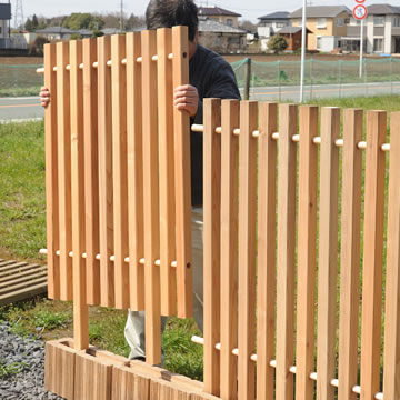 クロスポールフェンス、木べえさん。杉ヒノキの縦格子フェンス、防腐処理で長寿命、リバーシブル。コンクリートブロックの上に立てる施工例